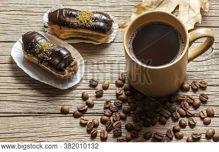 Eclairs With Pistachio And Black Chocolate And White Chocolate With Custard On Wooden Background And