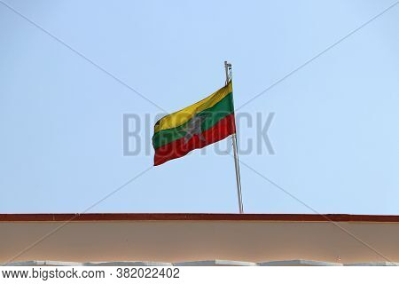 Myanmar Flag Blown By The Wind On The Roof With Blue Sky Background.