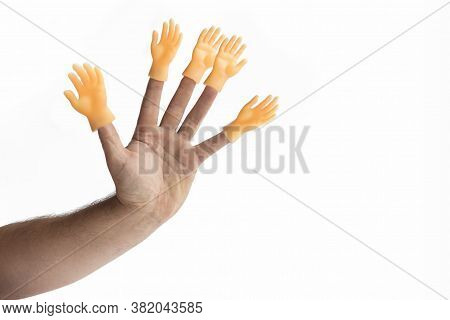 Hand On A White Background On Her Fingers Is Wearing A Toy In The Shape Of A Hand. Concept. No Choic