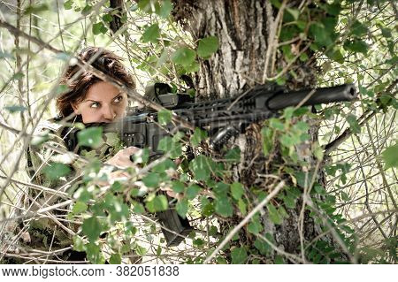 Attractive Woman Soldier Shooting With Rifle Machine Gun In Forest