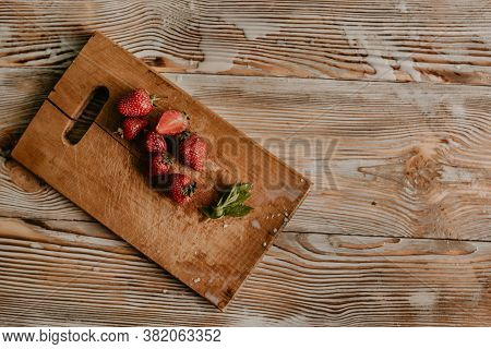 Juicy Red Strawberry Lies On The Wooden Board