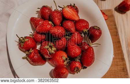 Juicy Red Strawberry Lies On The Wooden Board