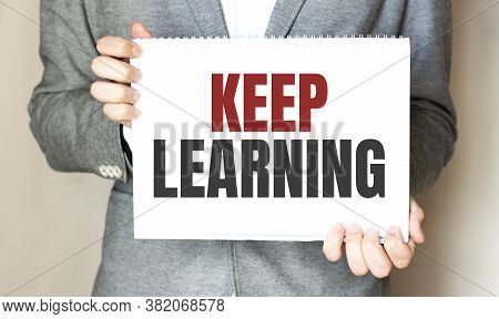 Businessman Holding A Card With Text Keep Learning
