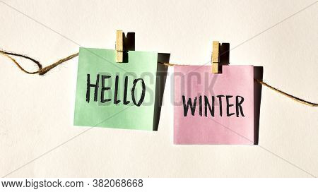 Hello Winter Text Words Inscription On Yellow Sticker Note On White Wall Or Table.