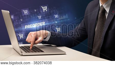 Businessman working on laptop with PREORDER inscription, online shopping concept