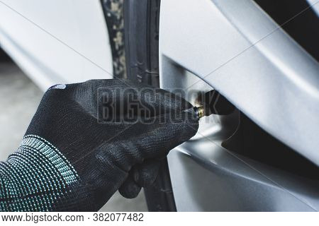 Hand Of Mechanic Are Putting Tire Valve Stem Cover Of Car Alloy Wheel