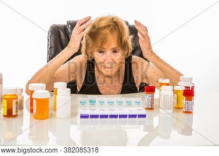 Senior Woman Overwhelmed Over Amount Of Pills For Her Pill Box