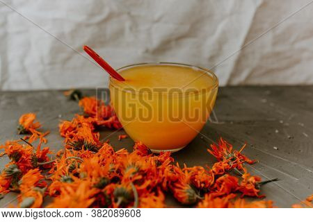 A Small Cup Is Filled To The Top With Yellow Liquid Honey, Orange Calendula.