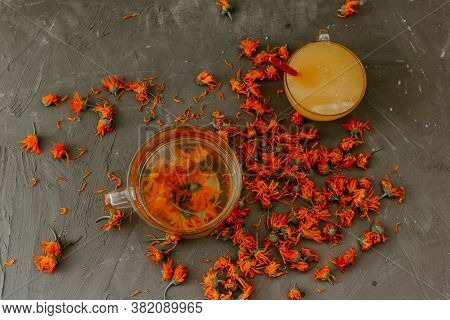Flower Tea In A Large Transparent Mug. A Small Cup Is Filled To The Top With Yellow Liquid Honey, Or