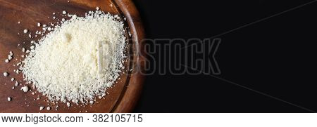 Parmesan. Finely grated cheese on black background. Shredded Parmesan cheese