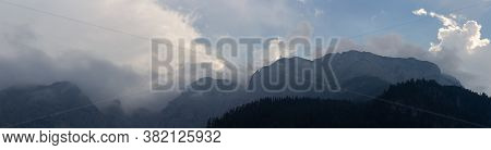 Panoramic View To Misty Fog After Rain On Austia Alps Mountain Silhouette With Blue Sky