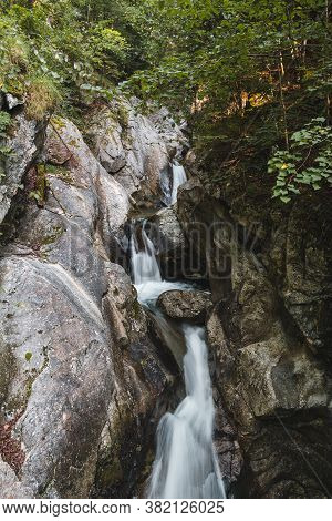 Close Up Rindbach Waterfall From Wooden Bridge With Forest. Austria Alps Mountain