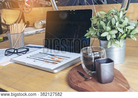 Office Laptop Business Financial Document Chart And Graph On Wooden Table With Coffee Cup. Flat Lay 