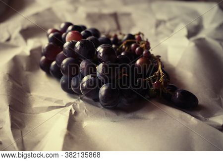 Branch Of Large Blue Grapes Close-up On Craft Paper
