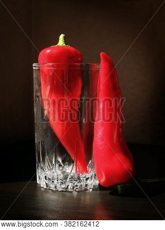 Still Life With Two Red Ramiro Peppers And The Glass Beaker Against A Low Key Background. Shallow De