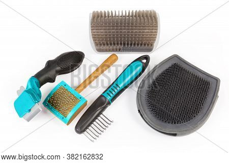 Different Combs And Brushes For Care Of Pets Hair On A White Background