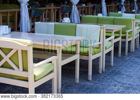 Summer Terrace Veranda Of A Cafe. Cozy Green Wooden Chairs And Tables