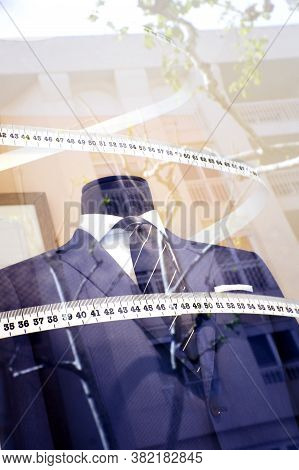 Mannequin In A Mens Suit Surrounded By A Tailors Tape Measure. No People
