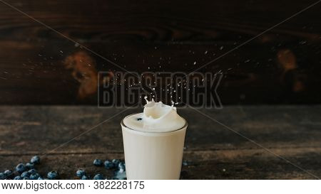 Berries Are Thrown Into The Transparent Glass Making Splashes Of Milk