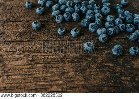 Blue Fresh Blueberries Are Scattered On An Wooden Table.