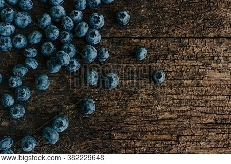 Blue Fresh Blueberries Are Scattered On An Wooden Table.