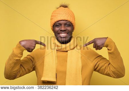 African Man In Warm Clothes Pointing With Fingers On Chest. Select Me Please.