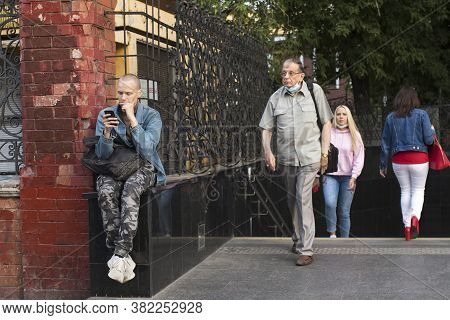 Moscow, Russia - 20.08.2020, People Leave The Kitay-gorod Metro Station In The Evening. Bald Boy Sit