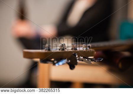 Tuning Pegs And Fretboard Bass Guitar Close Up On The Background Of The Musicians Apartment With Cop