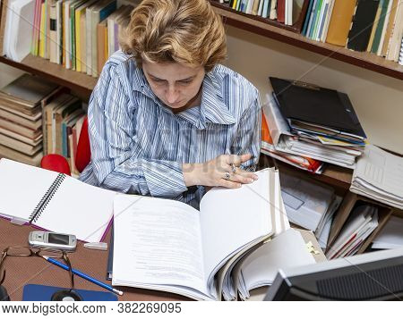 Image Of A Busy Woman Teleworking At Her Desk At The Home. Working At Home Became An Important Recom