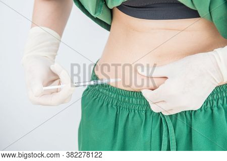 Shot Of Woman Hand With Syringe Inject Insulin To Her Belly. Diabetes Injection And Health Care Conc