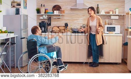 Wife Screaming In Kitchen To Her Disabled Man In Wheelchair While Having A Disagreement. Guy With Pa