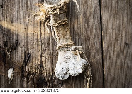 Door Handle In The Form Of A Hanging Bone On A Rope On A Wooden Door