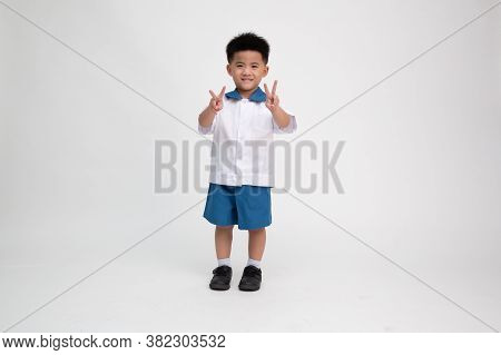 Asian Little Boy In Student Uniform With Shows Two Fingers Sign Isolated On White Background, First 
