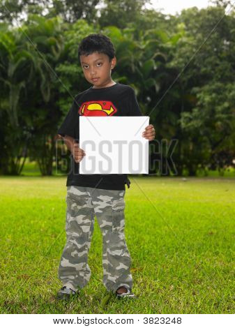 空白のプラカード庭のアジアの少年