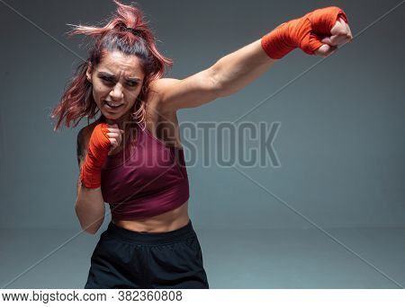 Beautiful Female Fighter Boxing In Studio Isolated On Gray Background. Mixed Martial Arts Poster