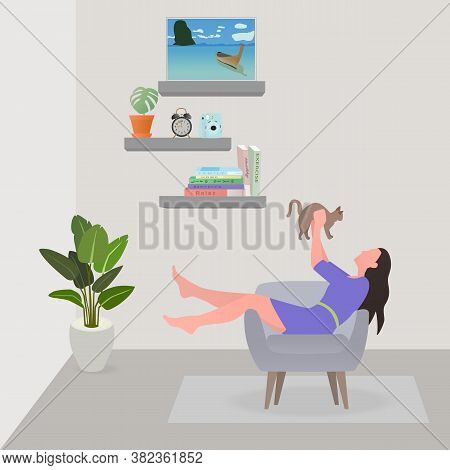 Woman Sitting On Sofa At Living Room And Playing With Cat. She Held  Cat With Both Hands. On Holiday