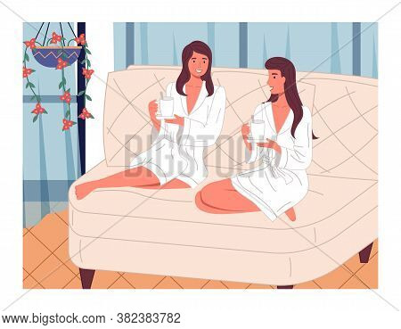 Two Young Beautiful Smiling Women Are Sitting With Bent Legs On A Large Bright Comfortable Sofa With