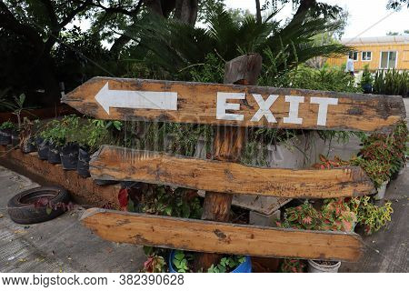 A Wooden Exit Sign Board Showing Direction