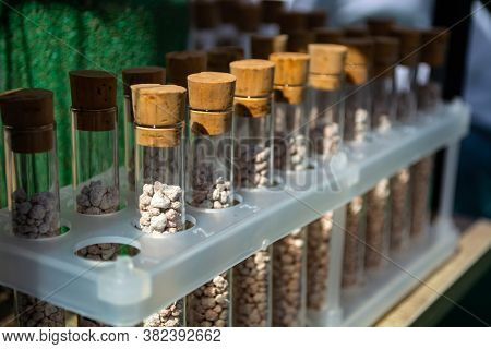 Multi-colored Granules Of Micronutrient Fertilizer In Test Tubes In A Row
