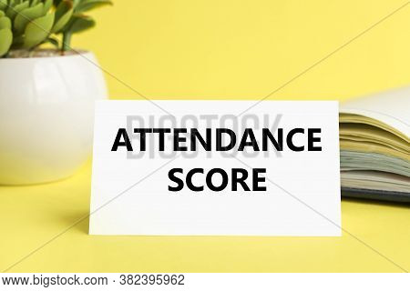 Attendance Score. Text On White Paper On Yellow Background. Flowerpot Book On Background
