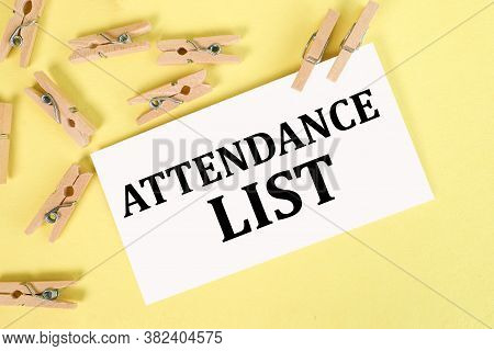 Attendance List. Text On White Paper On A Yellow Background. Wooden Clothespins