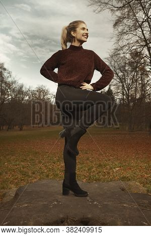 Nice Lady Posing In Autumn Park And Exercising With Steel Hoop