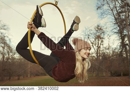 Nice Lady Posing In Autumn Park And Exercising With Steel Hoop