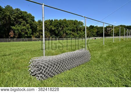 An Enclosed Metal Mesh Fence Is In The Progress Of Being Built With Posts In The Ground And Mesh As 