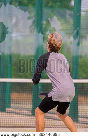 Focused Young Man Wearing Glasses Waiting For The Ball At A Paddle Court On An Out Of Focus Backgrou
