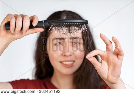 Portrait In A Blur, A Perplexed Brunette Woman Holds A Comb Over Her, Clearing It From A Pile Of Fal