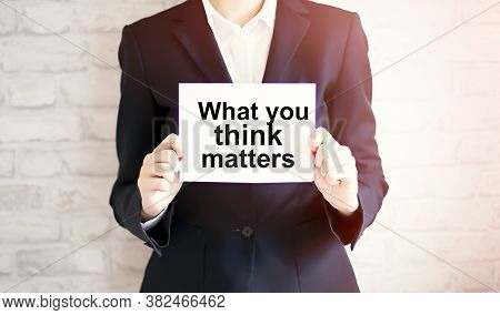 Woman Showing White Card With What You Think Matters Word . Business Concept