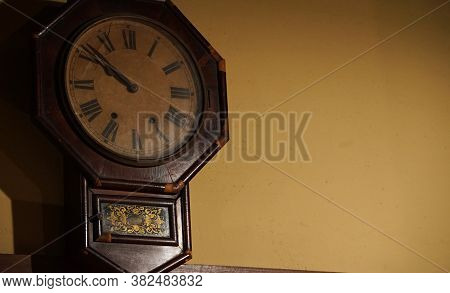 The Old Wooden Wall Clock Which Was Hung On The Wall Of The Room