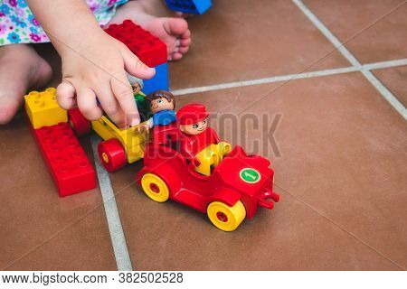 A Single Child Playing With Duplo Toys, Figures And Vehicles