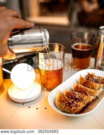Pouring Cool Beer In A Glass From Can On The Table With Gedza Dumplings